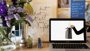 Desk with flowers, crystals and a laptop showing Girl Boss gift guide blog post